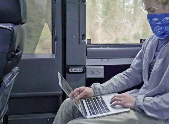 Passenger on Ambassador coach using laptop